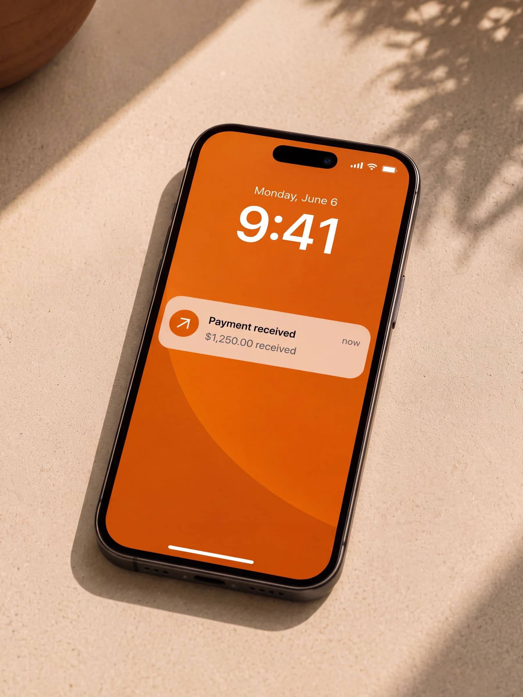 A phone on a sunlit surface showing a payment-received notification