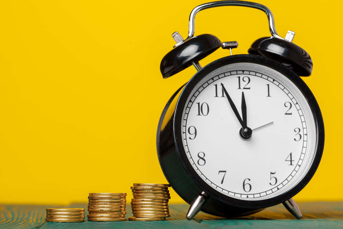 money table clock with coins and yellow background